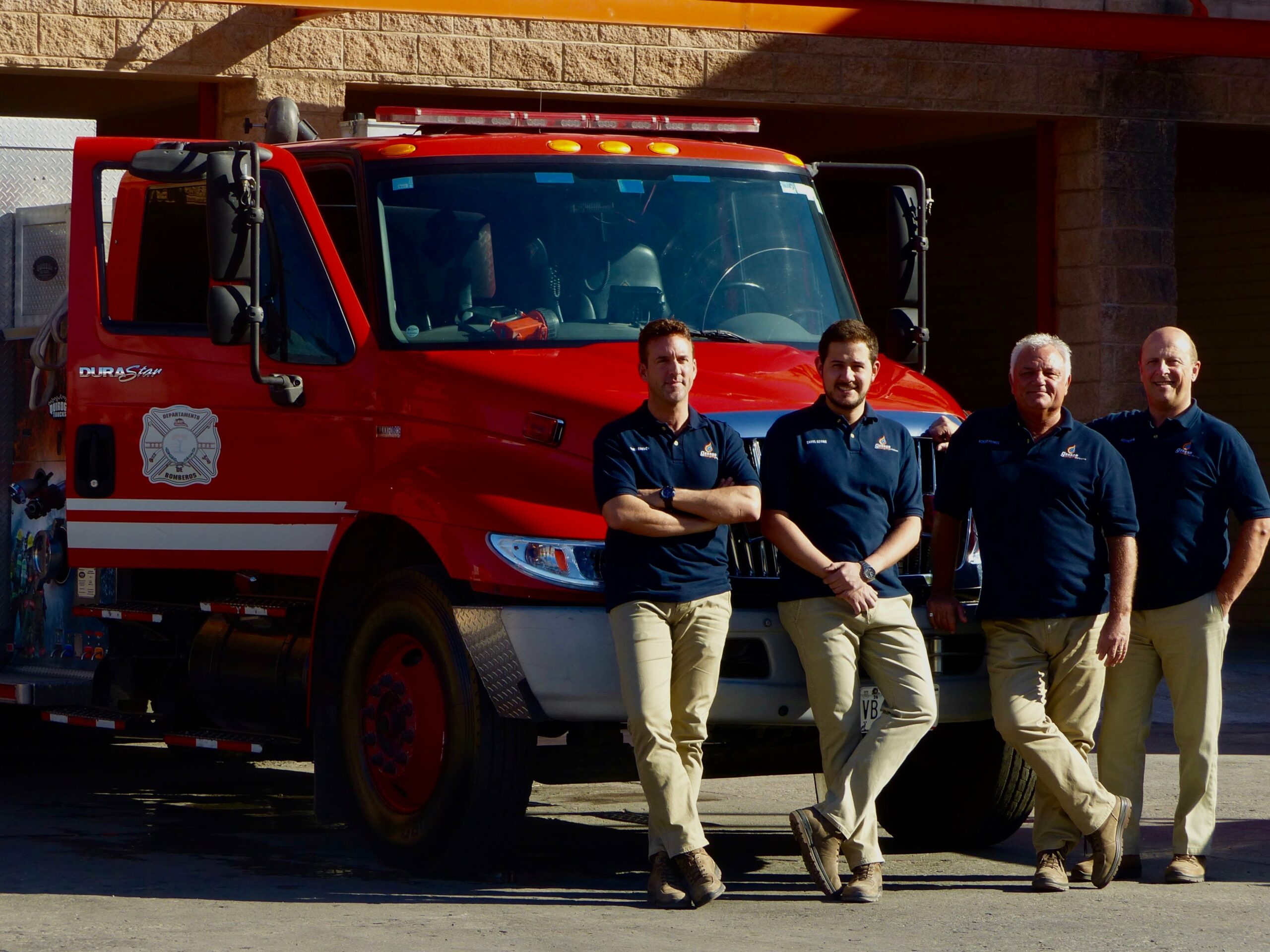 Firefighters posing in front of fire truck